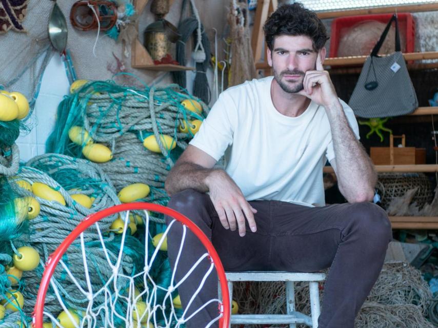 Carlos Martínez con redes de pesca que se reciclan para canastas de baloncesto.