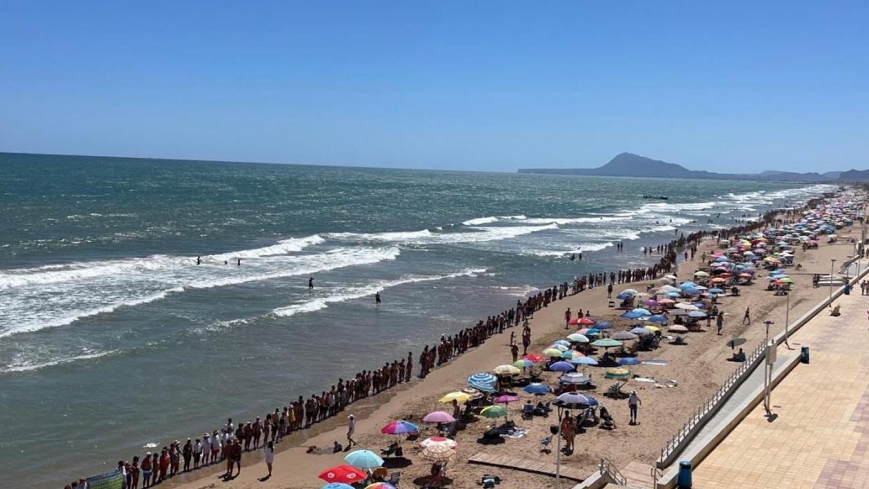 Cadena humana en playa de Bellreguard en agosto 2023.