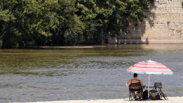 Una mujer toma el sol en la playa de las Moreras de Valladolid.