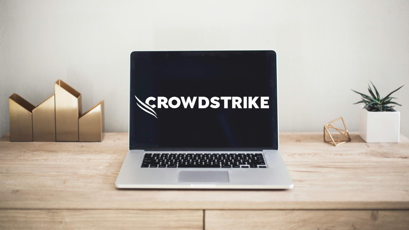 Fotomontaje de un ordenador y el logo de CrowdStrike.
