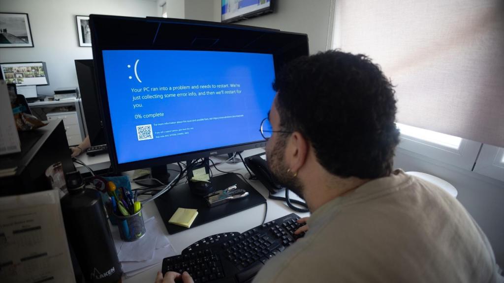 Un trabajador de oficina con la pantalla azul tras el fallo de Crowdstrike.
