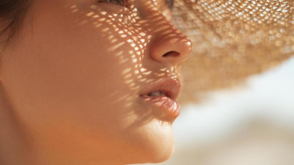 Mujer con sombrero tomando el sol.