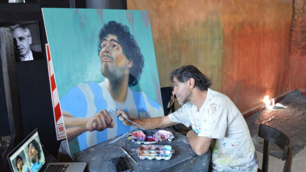 El artista muralista Juan Danna pitando a Maradona.