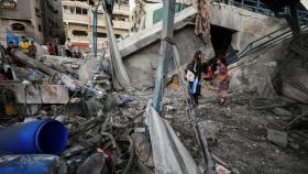 Palestinos entre los escombros de una escuela administrada por la ONU que alberga a personas desplazadas, tras un ataque israelí, en medio del conflicto entre Israel y Hamas, en la ciudad de Gaza.
