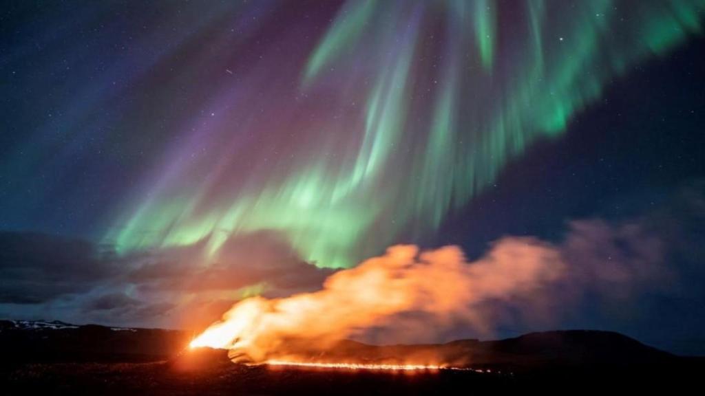 Foto actual de un volcán islandés bajo la aurora boreal