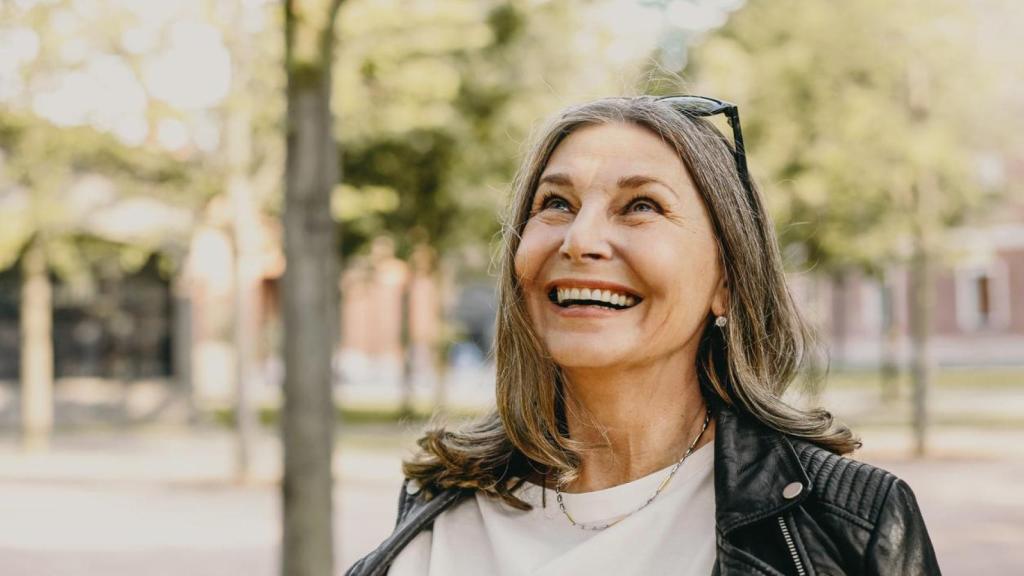 Mujer madura sonriente paseando al aire libre.