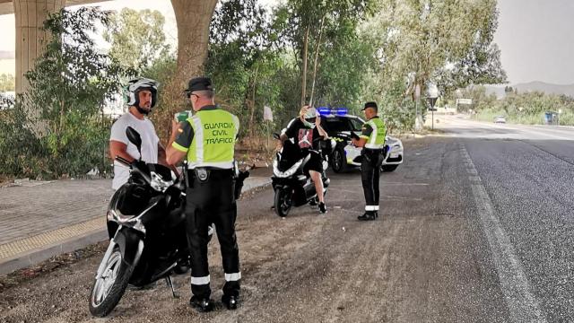 Guardias civiles de Tráfico informan a dos motoristas en Málaga.