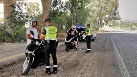 Guardias civiles de Tráfico informan a dos motoristas en Málaga.
