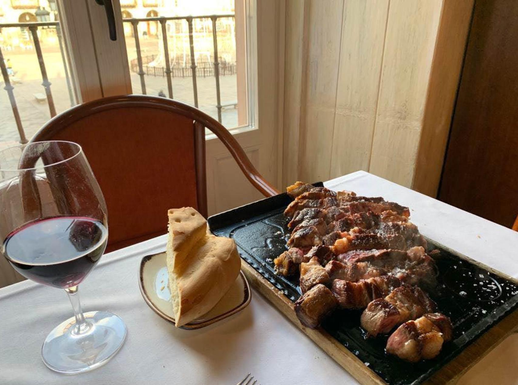 Degustar un buen chuletón de ternera de Salamanca,  junto al balcón que mira a la Plaza Mayor