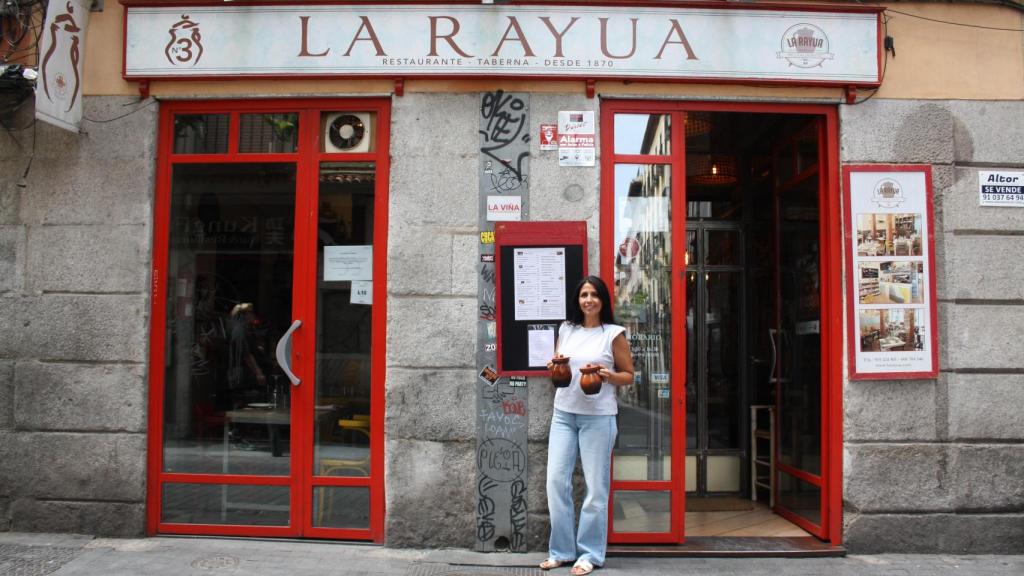 Sara Verdasco con en la entrada de La Rayua con dos pucheros de barro.