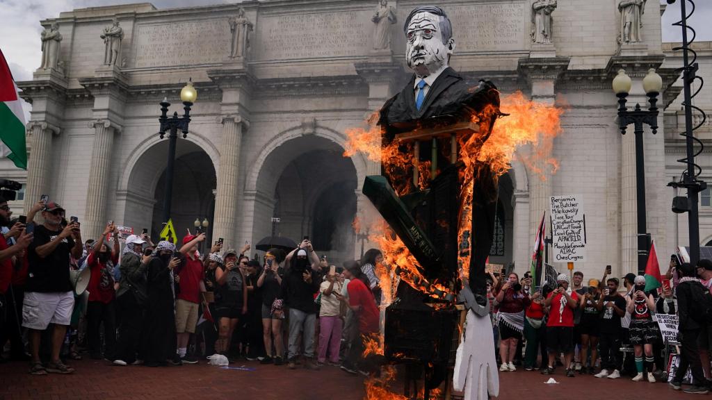 Varios manifestantes propalestinos queman una bandera estadounidense y una representación de Netanyahu.