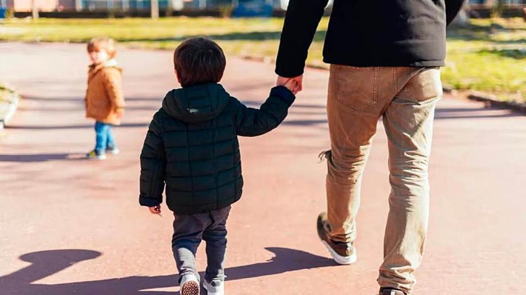 Un padre con su hijo de la mano