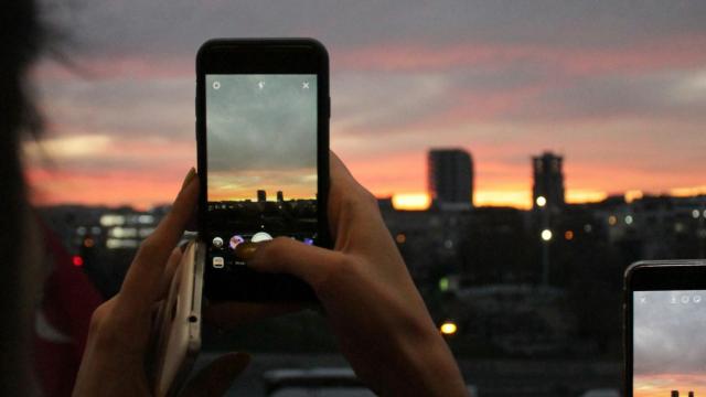 Haciendo fotos con el móvil al atardecer