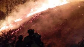 Un bombero del Plan INFOCA junto a las llamas del incendio de Casares.