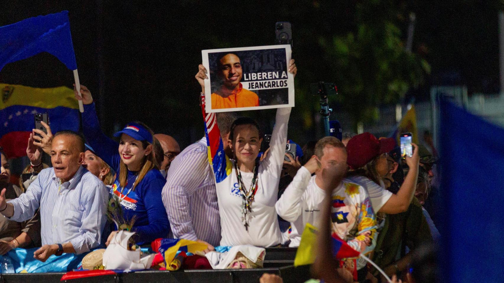 María Corina Machado, sostiene un cartel que dice Liberen a Jeancarlos durante un mitin de campaña con el candidato opositor Edmundo González