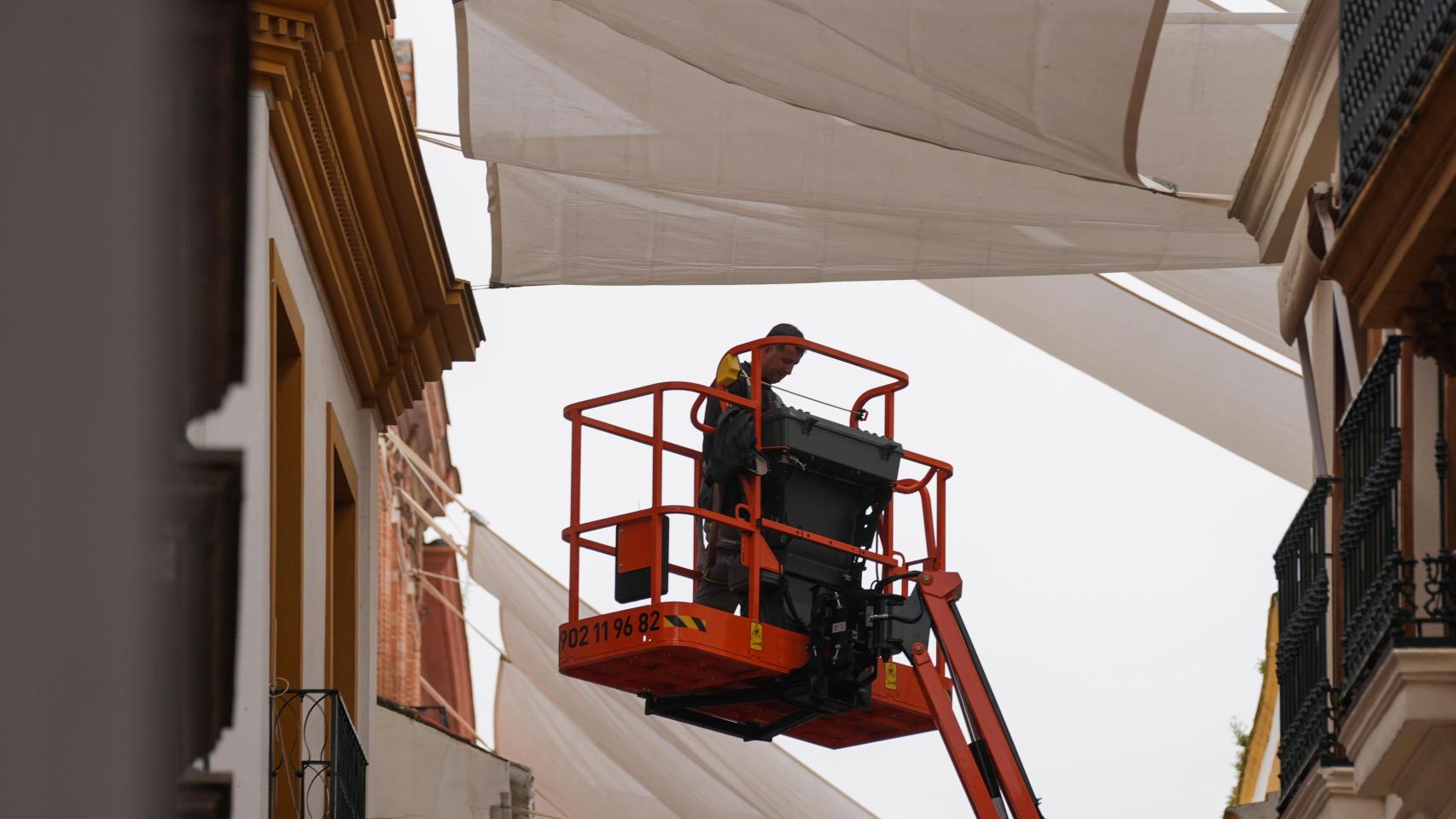 Un operario instala los toldos en la calle Sierpes de Sevilla.