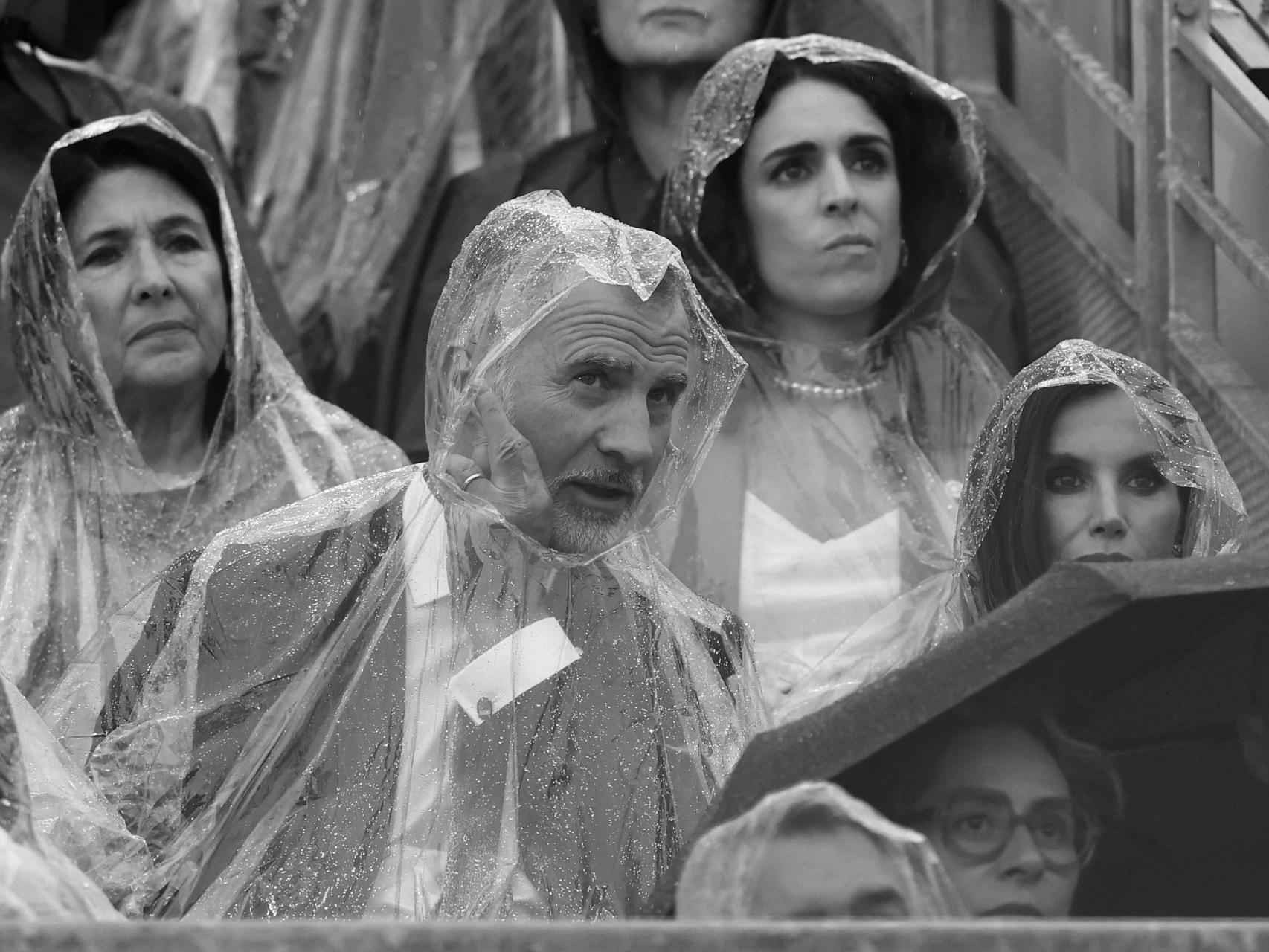 Los Reyes de España, protegidos de la lluvia durante la ceremonia inaugural de los JJOO.