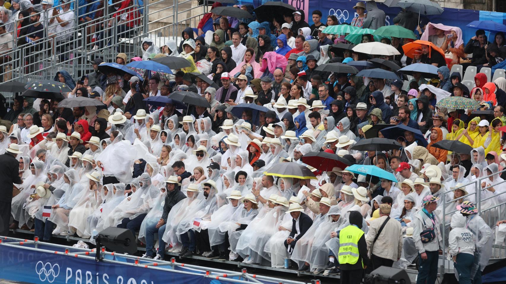 Espectadores protegiéndose de la lluvia
