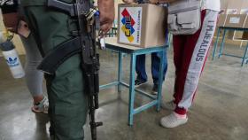 Un soldado da instrucciones a los voluntarios mientras preparan un colegio electoral, este viernes.