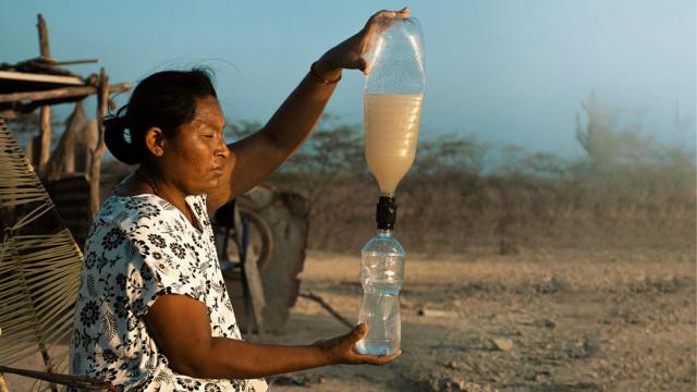 Una persona usando el tapón para filtrar y purificar agua.