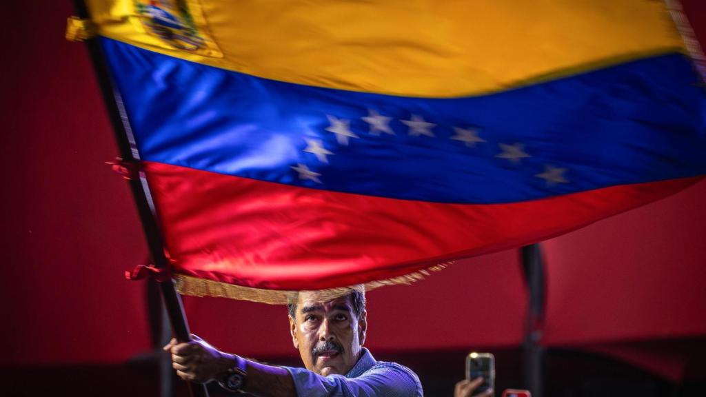 El presidente de Venezuela y aspirante a la reelección, Nicolás Maduro, agita una bandera en el cierre de su campaña este jueves, en Caracas (Venezuela).