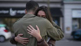 Una pareja se da un abrazo en la calle.