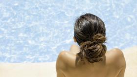 Una mujer haciendo 'topless' en una piscina.