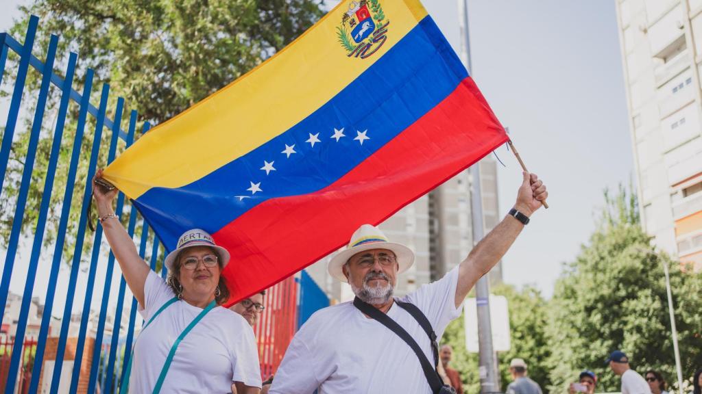 Una pareja ondea la bandera de Venezuela a las puertas del Centro Cultural Fernando de los Ríos.
