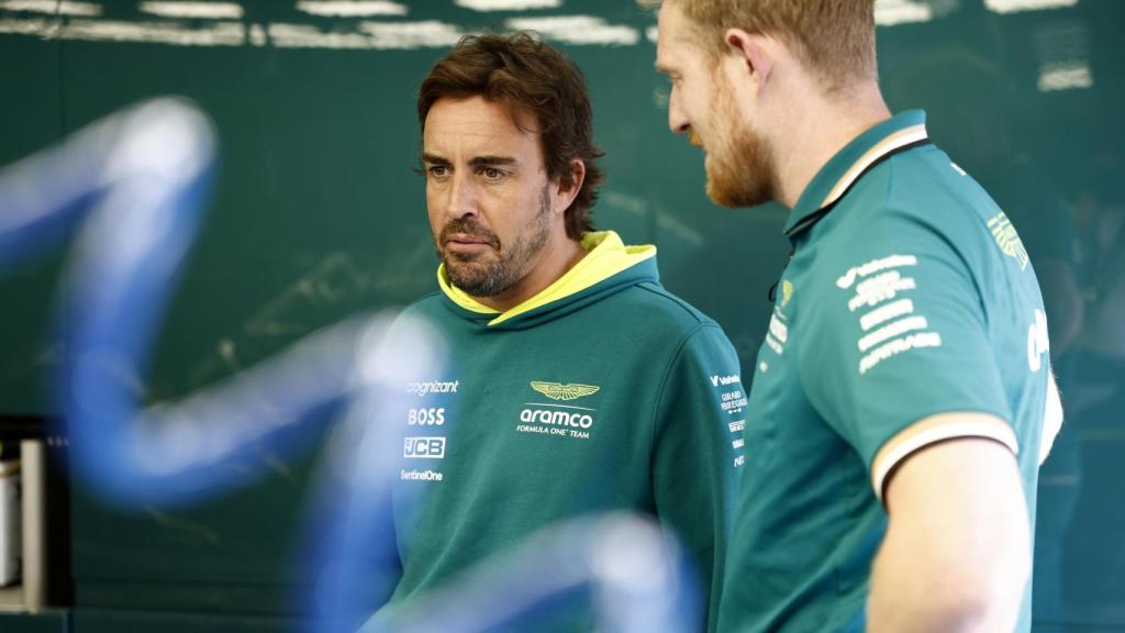 Fernando Alonso conversa con un mecánico de Aston Martin en el box