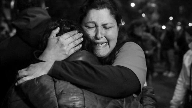 Una mujer venezolana se abraza a otra a las puertas de la embajada de su país en Buenos Aires.