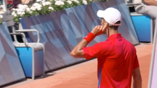 Novak Djokovic se toca la oreja tras poner el 5-4 en el segundo set.
