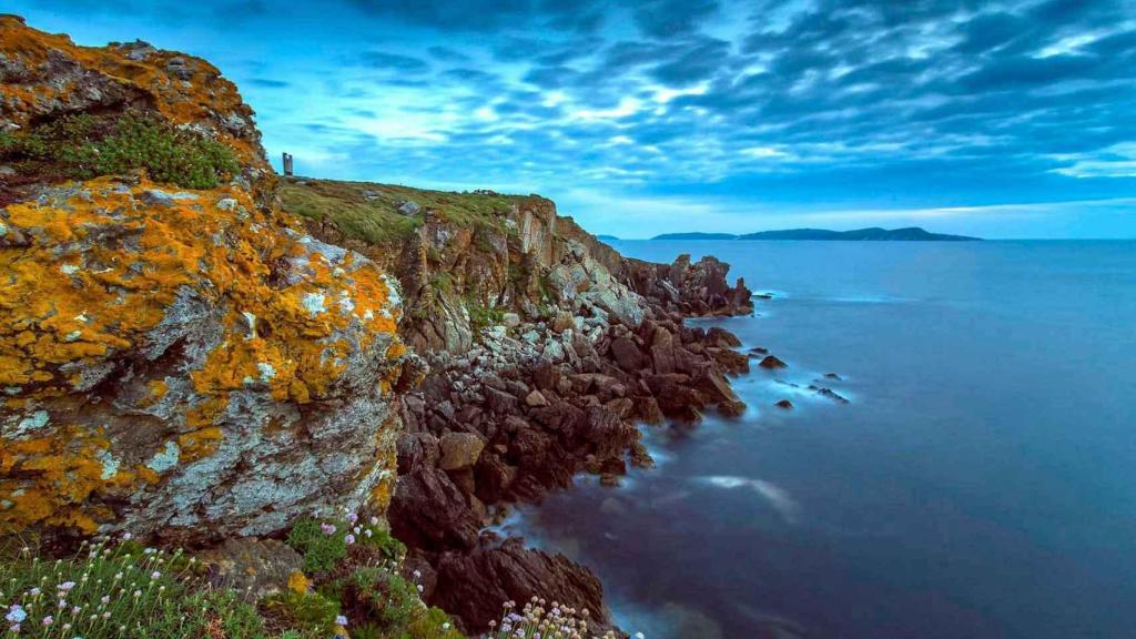 Panorámica de los acantilados de Punta Faxilda y las islas Ons al fondo