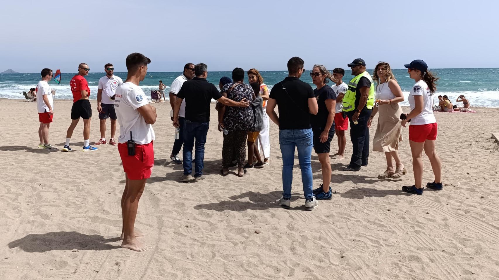 Miembros de Protección Civil y Servicios Sociales acompañan a la madre de Emmanuel cerca de la playa de Las Amoladeras donde desapareció su hijo, horas antes de que apareciese su cuerpo sin vida.