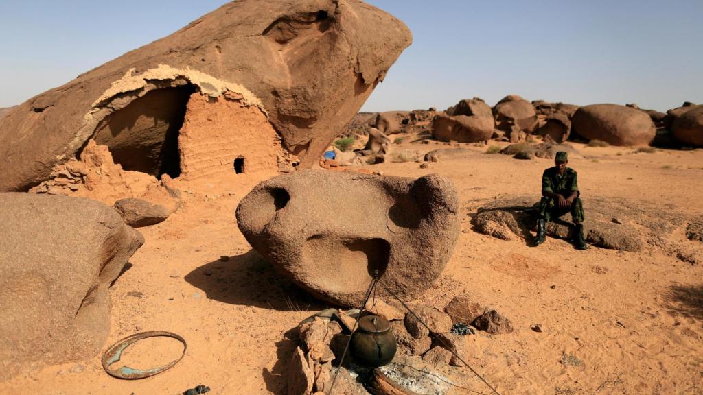 Un combatiente del Polisario se sienta en una roca en una base avanzada en las afueras de Tifariti, Sahara Occidental.