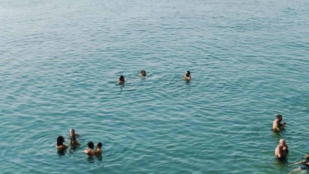 Veraneantes bañándose en la playa que está a los pies del chiringuito Saam