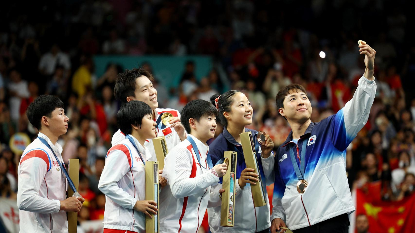 Atletas de Corea del Norte, Corea del Sur y China haciéndose un selfie.