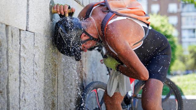 Un hombre se refresca en una fuente de Madrid Río durante una de las olas de calor de julio.