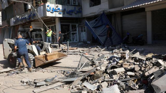 Miembros de la policía municipal retiran los escombros de un lugar dañado al día siguiente de un ataque israelí, en los suburbios del sur de Beirut, Líbano.