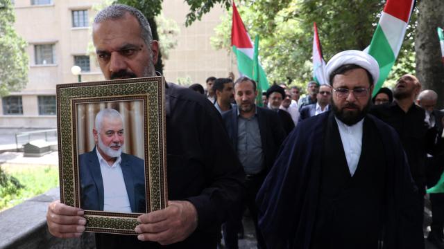 Varios hombres iraníes sostienen un marco con la imagen de Haniyeh este miércoles en Teherán, Irán.