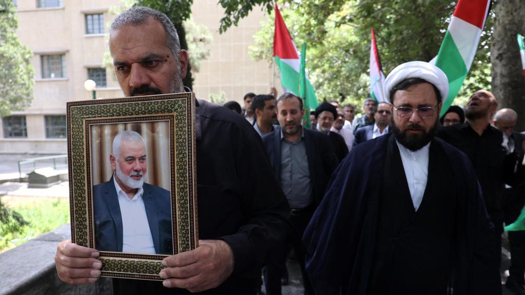 Varios hombres iraníes sostienen un marco con la imagen de Haniyeh este miércoles en Teherán, Irán.