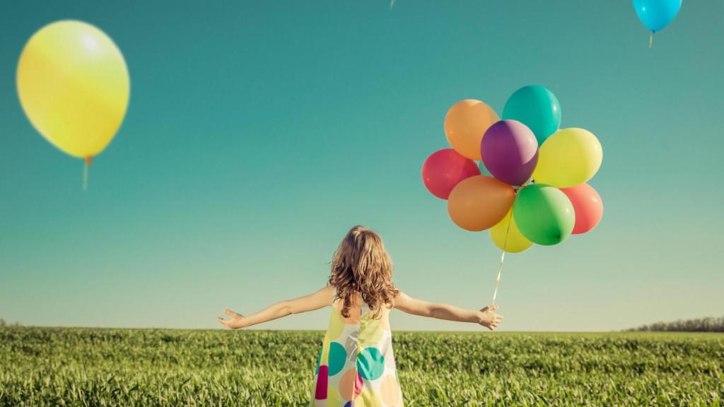 Una niña juega con globos.