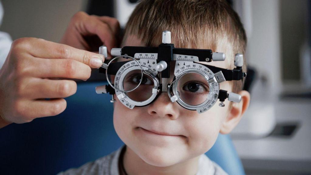Un oftalmólogo le comprueba la visión a un niño.