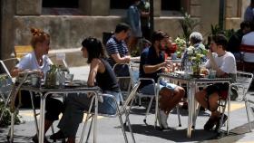 Varias personas en la terraza de un bar.