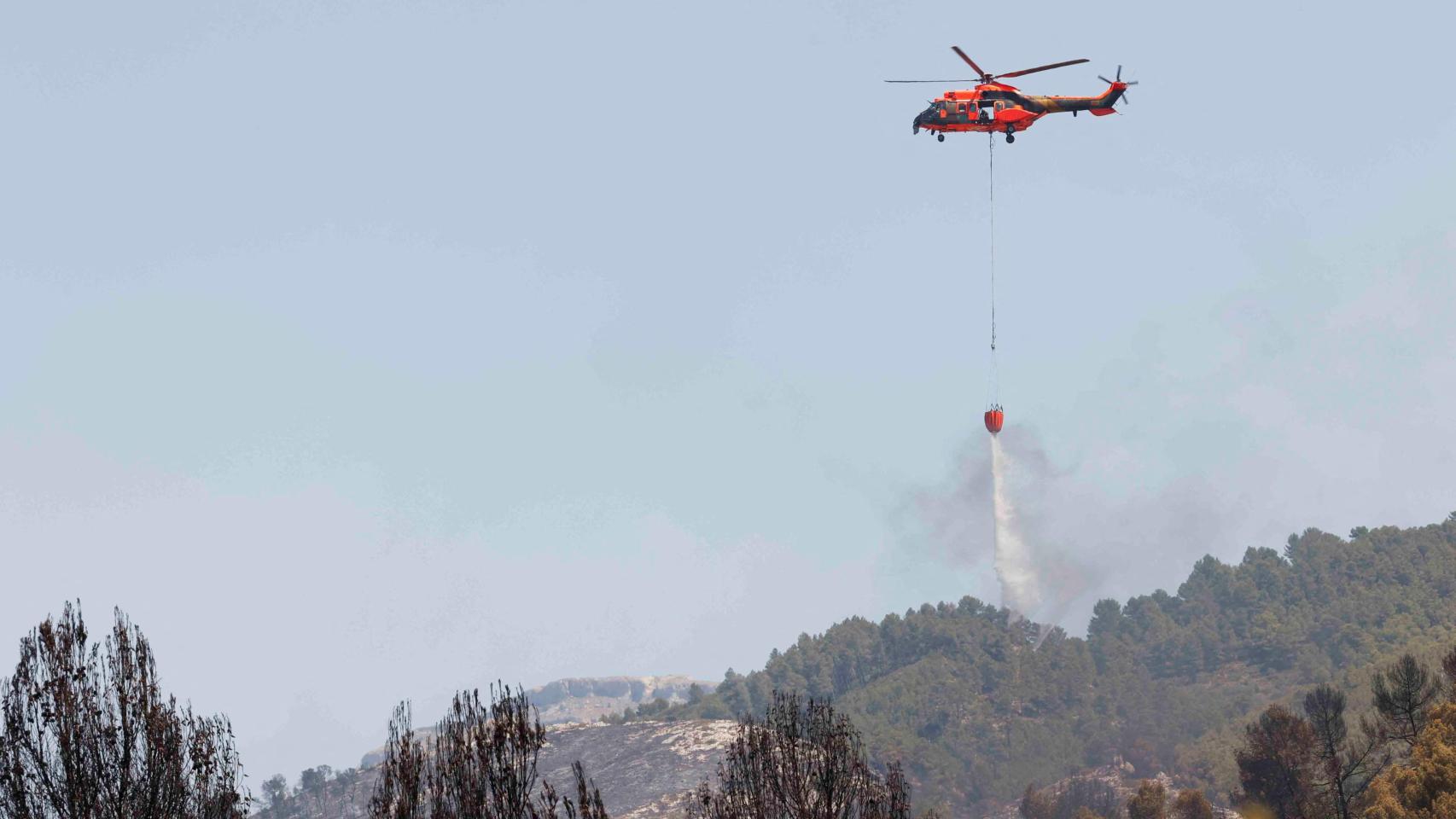 Un helicóptero de emergencia ayuda a apagar un incendio forestal en Penáguila (Comunidad Valenciana).
