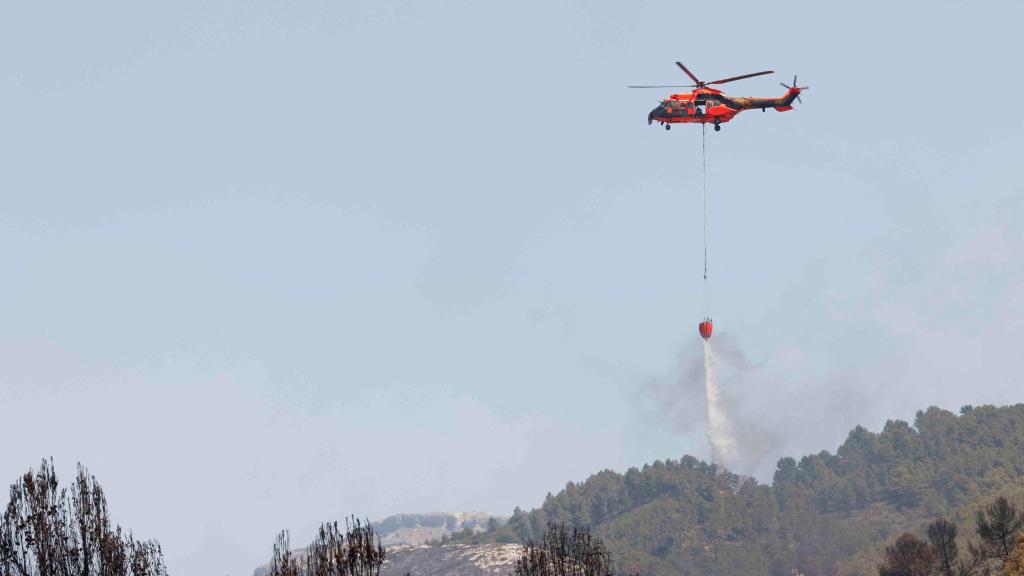 Un helicóptero de emergencia ayuda a apagar un incendio forestal en Penáguila (Comunidad Valenciana).