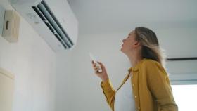 Una mujer disfrutando de su aire acondicionado.