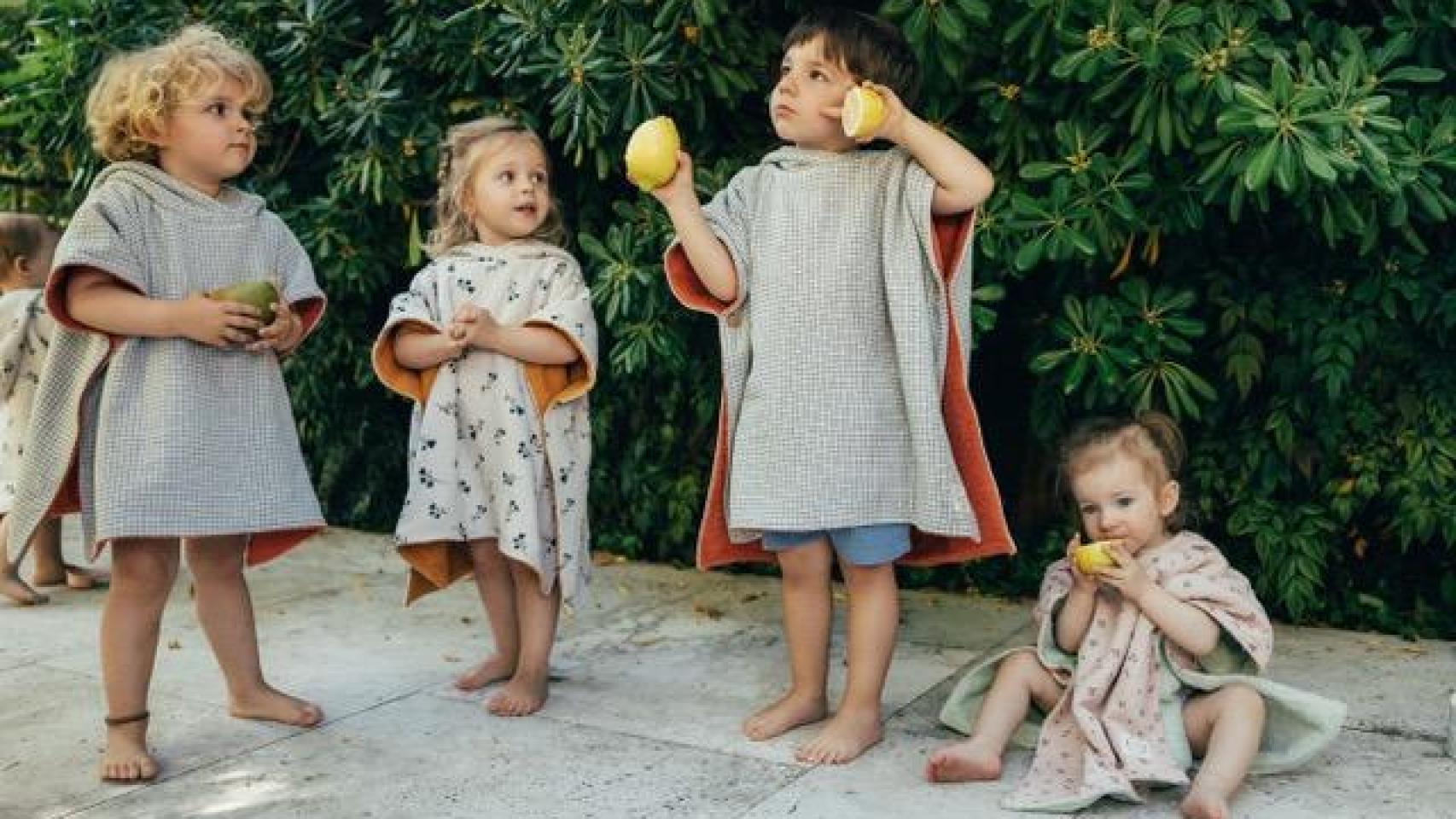 Niños pequeños luciendo los diferentes modelos de ponchos.