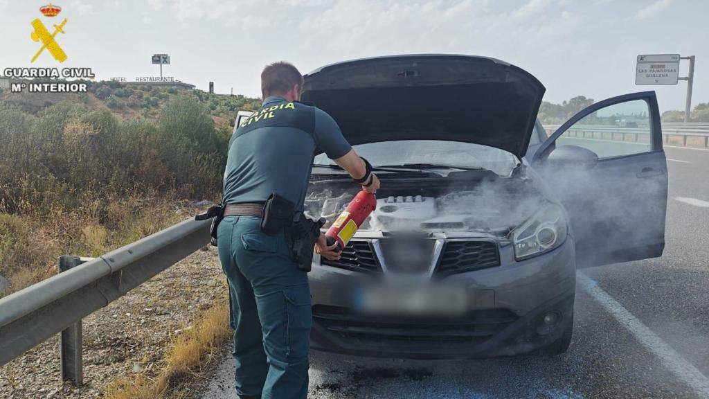 Agentes de la Guardia Civil apagando el incendio de un motor en la A-66