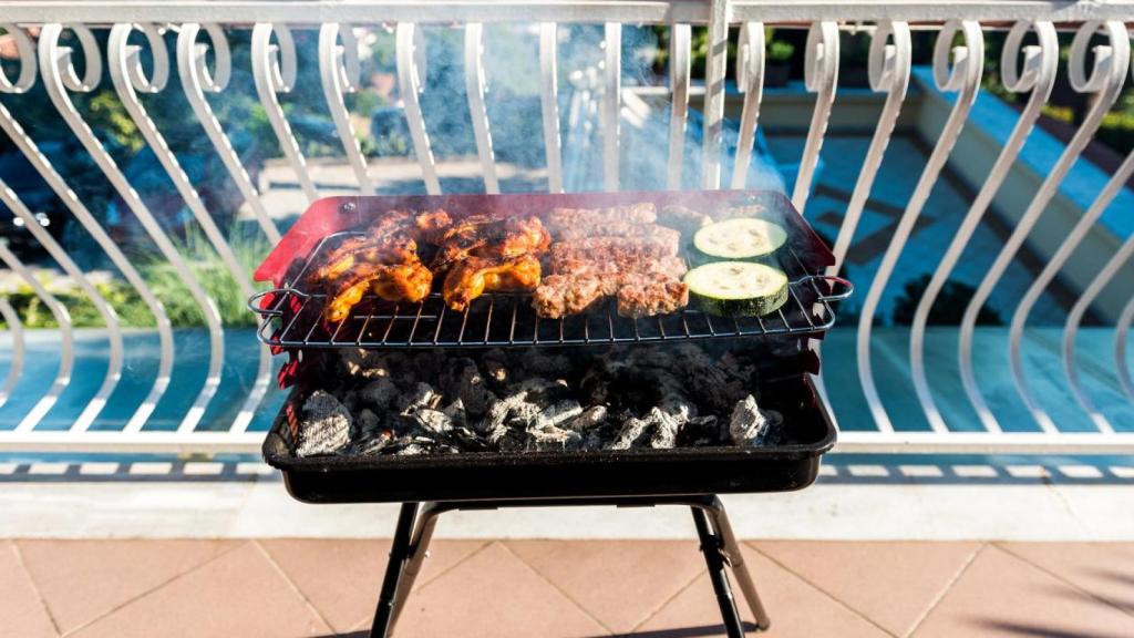 Una barbacoa de carbón en el balcón de una casa