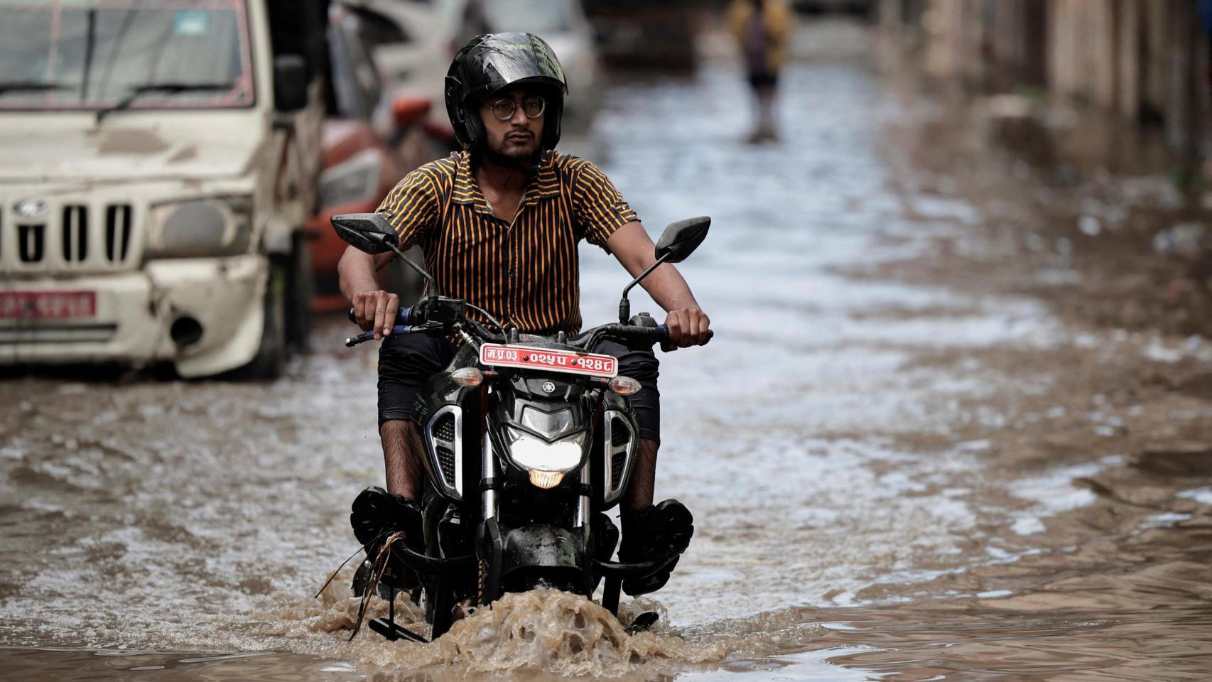 Un hombre recorre en moto una calle inundada de Katmandú, el pasado mes de julio.